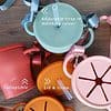 A variety of different colored cups with straps on them.