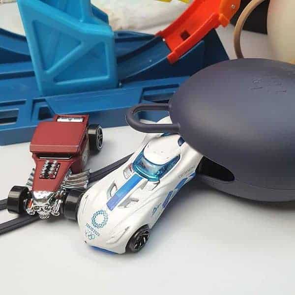 A toy car is sitting next to a toy mouse.