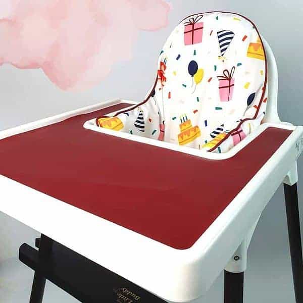 A high chair with a red seat cover.