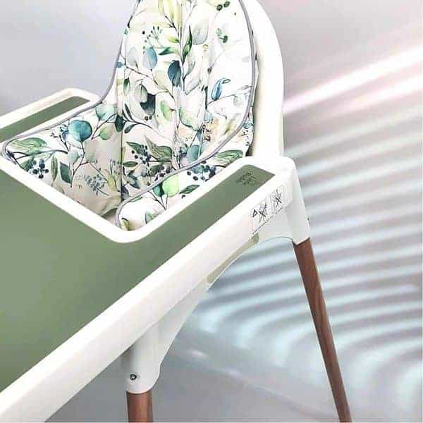 A high chair with a green and white floral pattern.