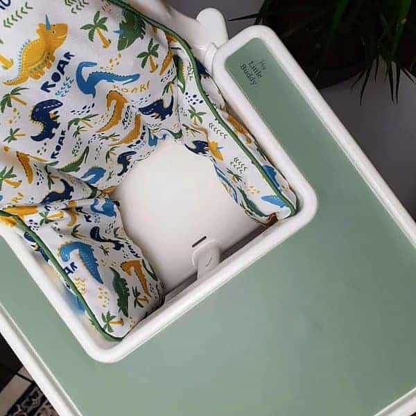 A baby's high chair with a green cover.