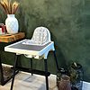 A high chair in front of a green wall. A high chair in front of a green wall.