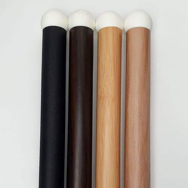 Four wooden broomsticks with white and black tips.