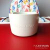 A little buddy high chair with a cup on it.