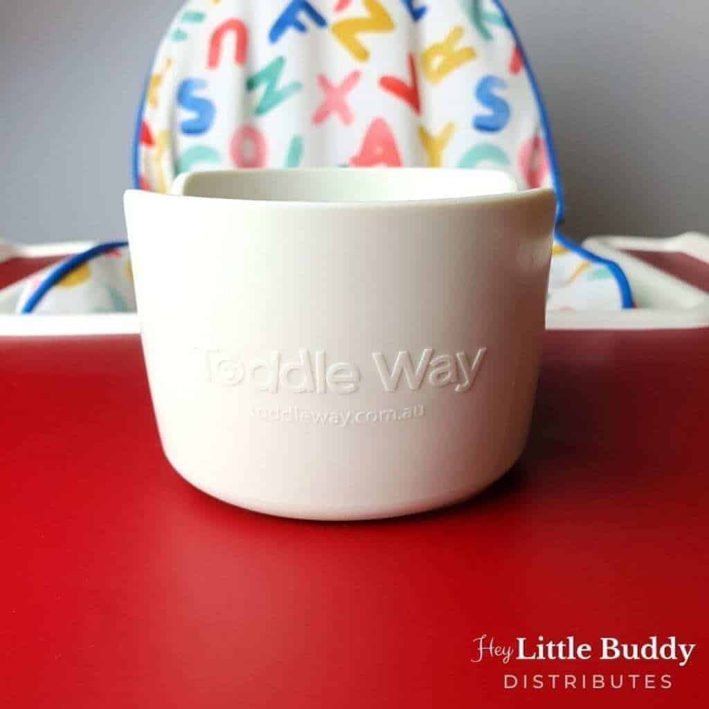 A little buddy high chair with a cup on it.